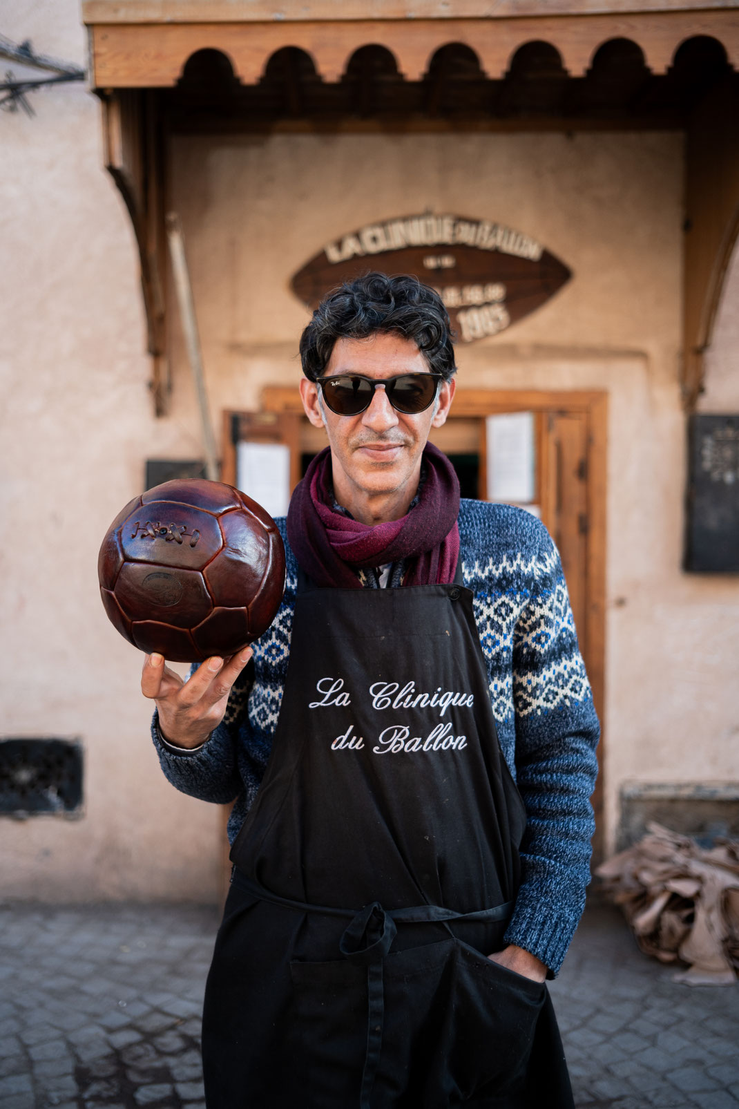 Kamal Boukentar holding a vintage football ball at La clinique du ballon - Marrakech Morocco