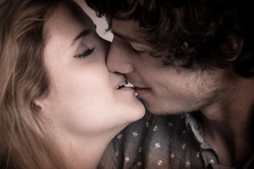 Ein junges verliebtes Paar bei einem Fotoshooting das sich küsst.