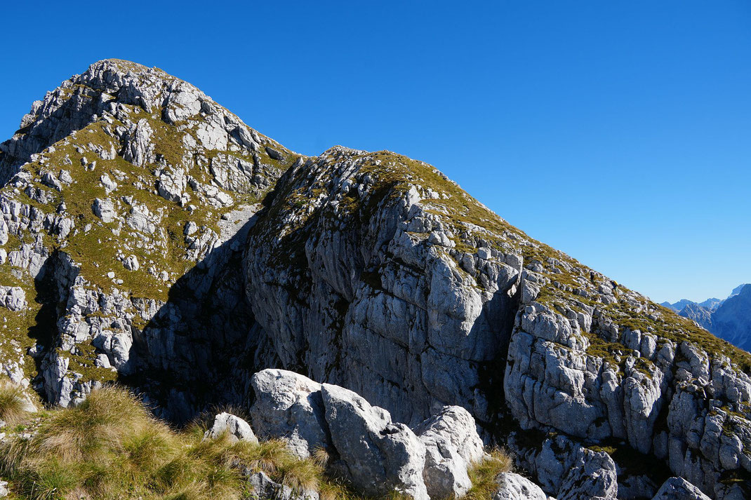 Blick vom Vrh Nakla hinauf zum Rombon (rechts vorne sind zwei Bergsteiger zu erkennen)