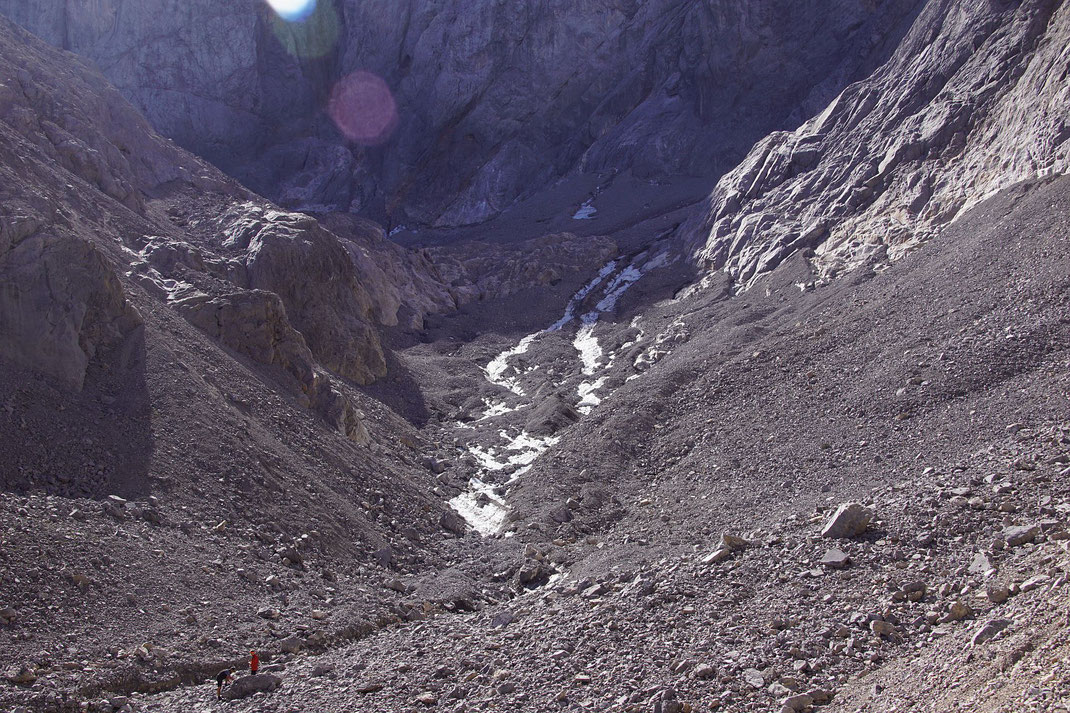 Die fast komplett mit Schutt bedeckte Gletscherzunge, im Vordergrund links erkennt man als Größenvergleich zwei Personen