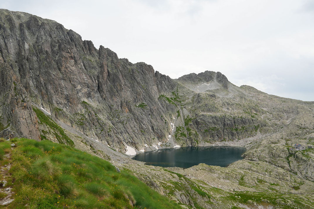 Blick vom Col Verde zum Lago di Cima d'Asta und der Schutzhütte; der Aufstieg zur Cima d'Asta erfolgt zunächst in den Sattel oberhalb des Sees