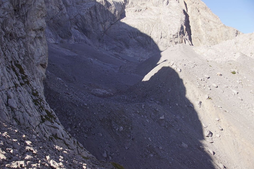 Blick vom Osten über den fast komplett mit Schutt bedeckten Gletscher. Der Gletscher liegt zwischen Felswand (links) und Moräne (Schuttwall, rechts)
