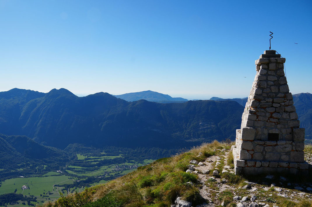 Čukla, das Tal tief unten, rechts und links neben dem Mahnmal zwei Gänsegeier