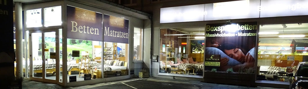 Ein Bild welches das Bettengeschäftes Schlafalm Bonn von Außen, mit kostenlosen Kundenparkplätzen direkt vor dem Eingang, zeigt.