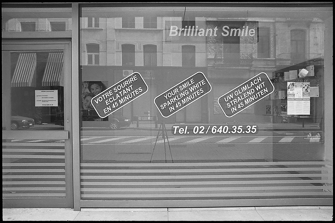 Photographie noir et blanc, vitrine avec annonce "votre sourire éclatant en 45 minutes" , Brilliant Smile