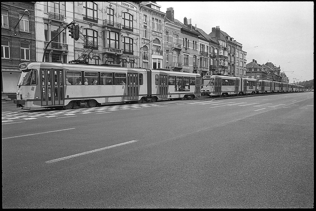 Photographie noir et blanc montrant au moins 7 tramways arrêtés et collés l'un à l'autre sur le Boulevard Général Jacques qui est un grand axe de circulation à Bruxelles. On ne voit curieusement aucune voiture sur l'image.