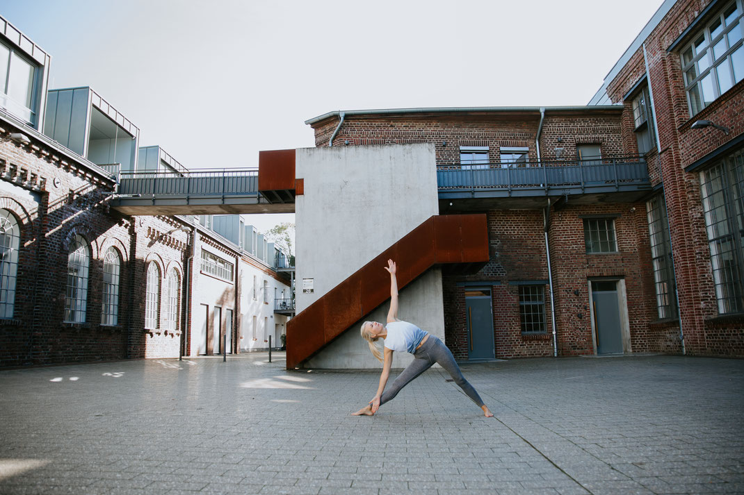 Yoga Trikonasansa auf Fabrikgelände