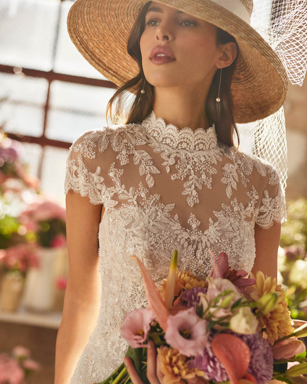 Junge Frau mit einem Hut trägt das Brautkleid Xiane aus der Rosa Clará Boheme Kollektion 2026