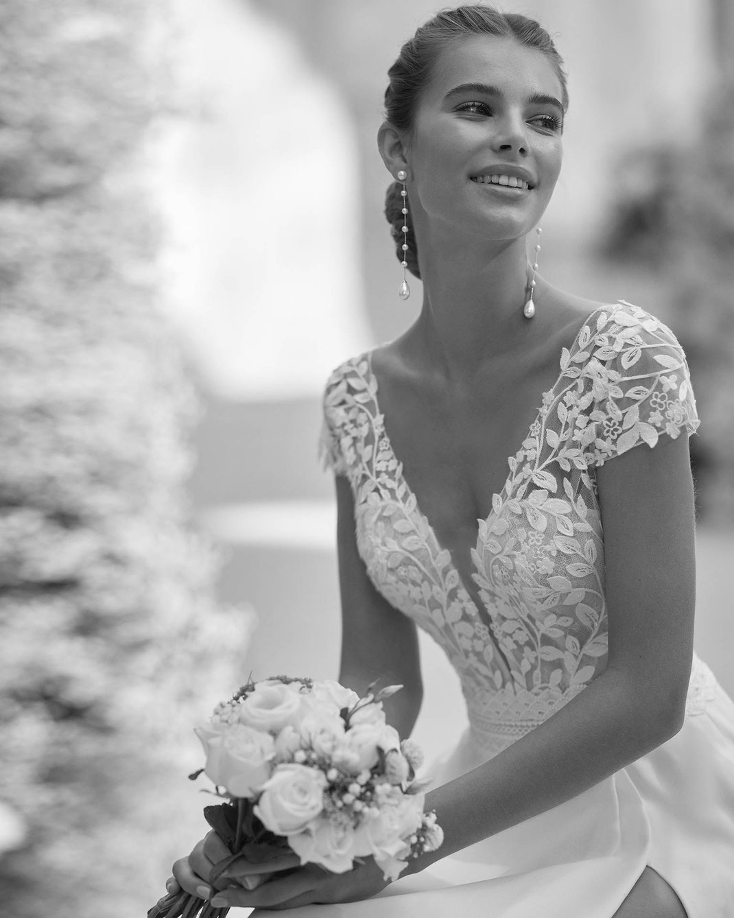 Junge Frau mit Brautstrauss trägt das Brautkleid Harden aus der Alma Novia Kollektion 2025