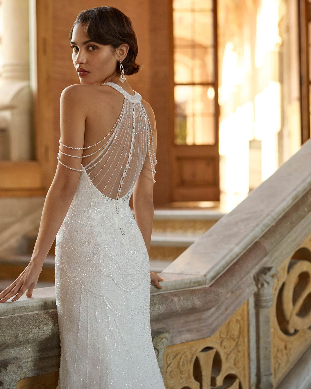 Junge Frau mit braunen kurzen Haaren trägt das Brautkleid Beryl aus der Rosa Clará Gatsby Kollektion 2026