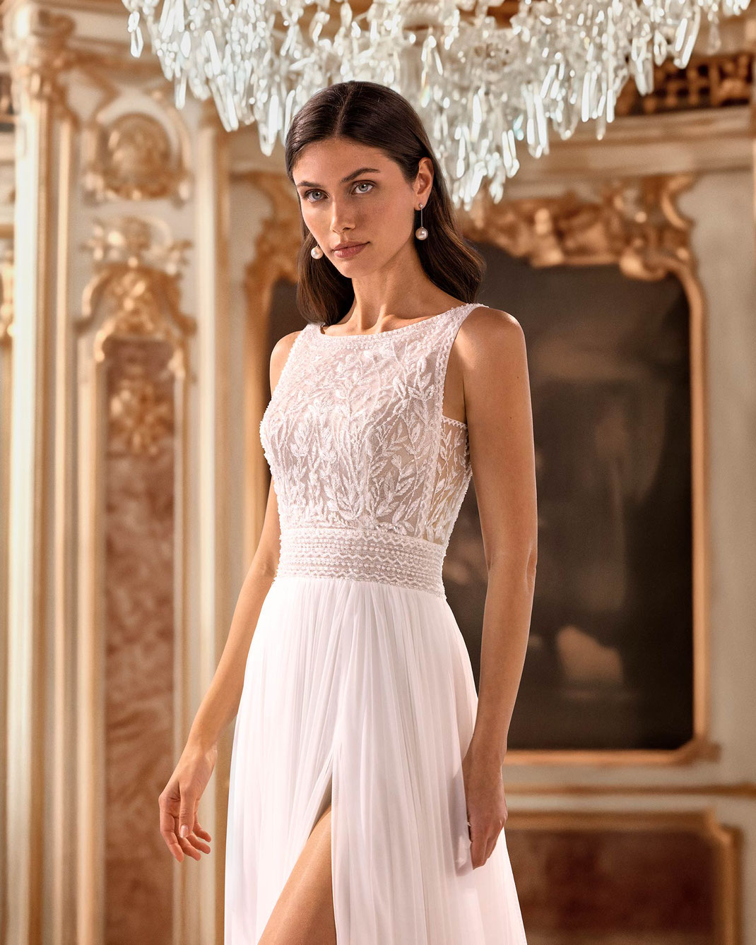 Junge elegante Frau in einer Villa trägt das Brautkleid Quiss aus der Aire Diamond Kollektion 2026