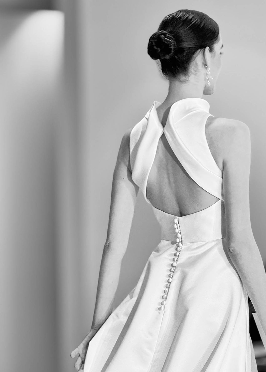 Model mit einem Brautkleid aus der Jesus Peiro Kollektion 2027 von hinten in Schwarzweiss auf dem Laufsteg in Barcelona