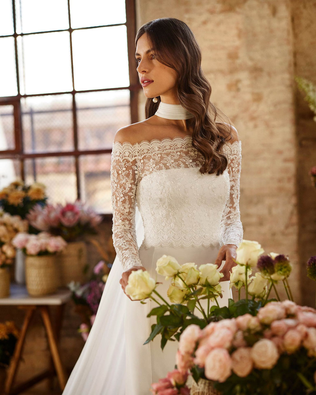 Junge Frau in einem Blumenladen trägt das Brautkleid Xandrin aus der Rosa Clará Boheme Kollektion 2026