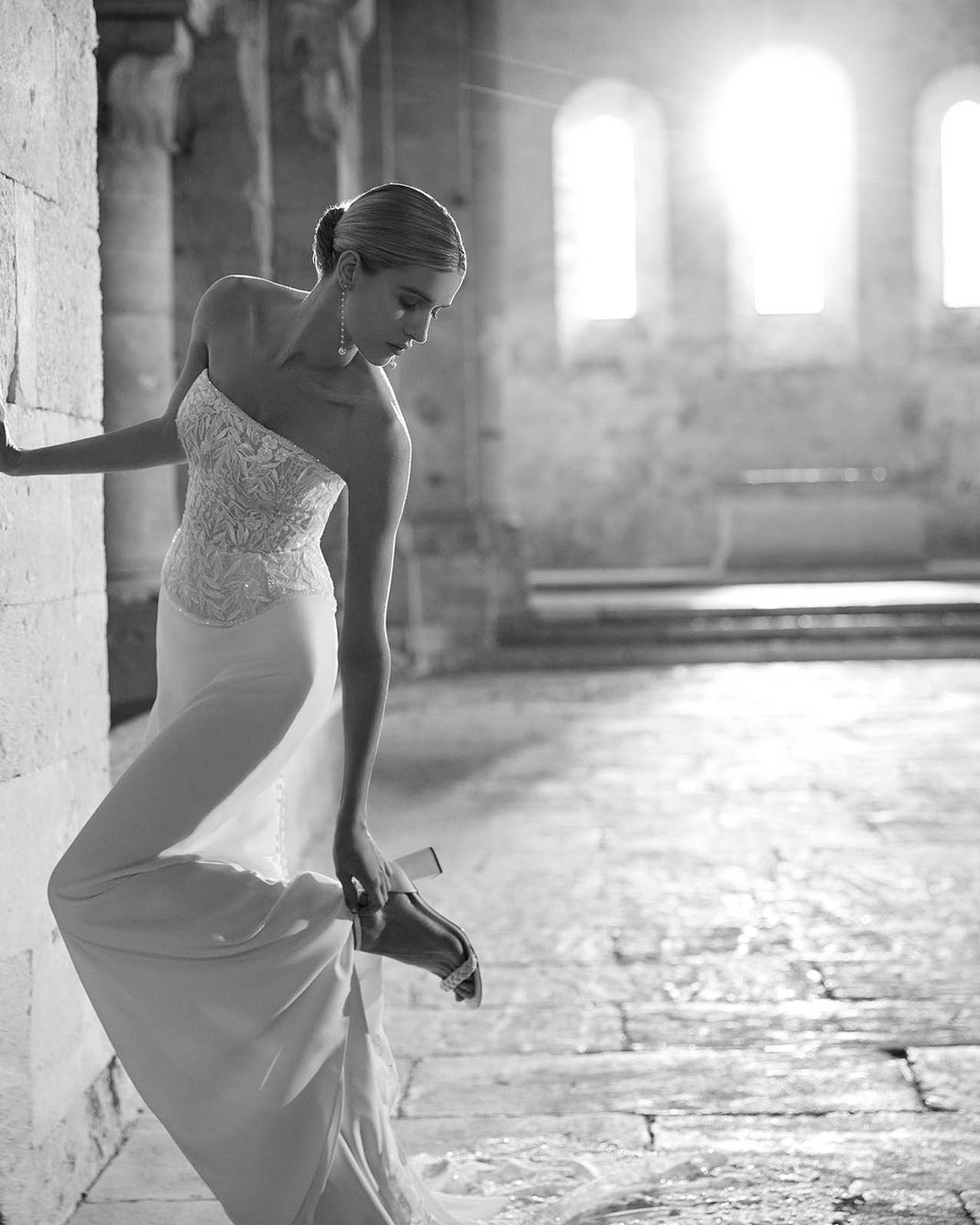 Elegante Frau in einer historischen Kirche trägt das Brautkleid Lilia von Rosa Clará Soft