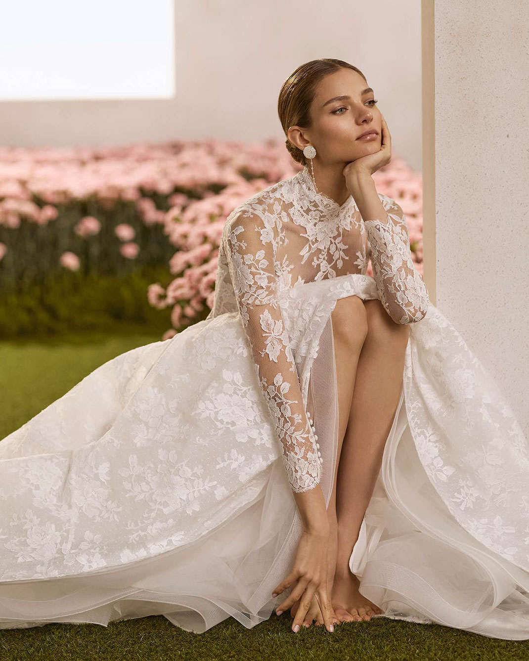 Junge elegante Frau sitzt in der Hocke und trägt das schöne Brautkleid Regio von Rosa Clará Couture