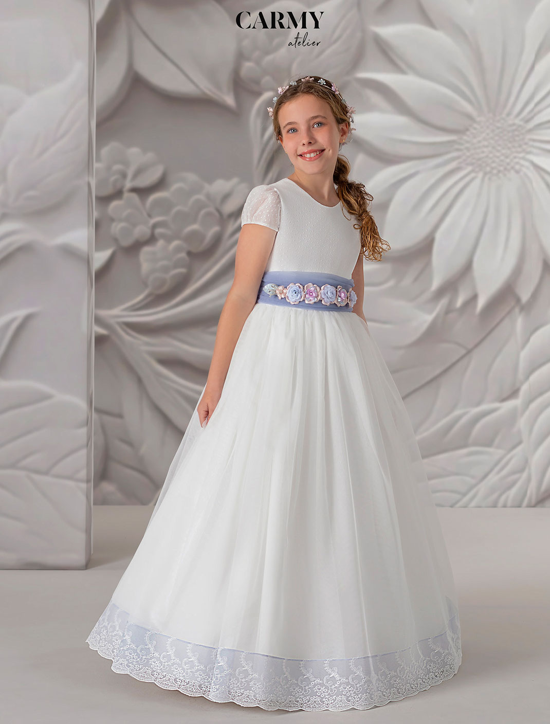 Mädchen trägt ein Kommunionkleid aus Chiffon aus der Kollektion Carmy Kommunion 2025