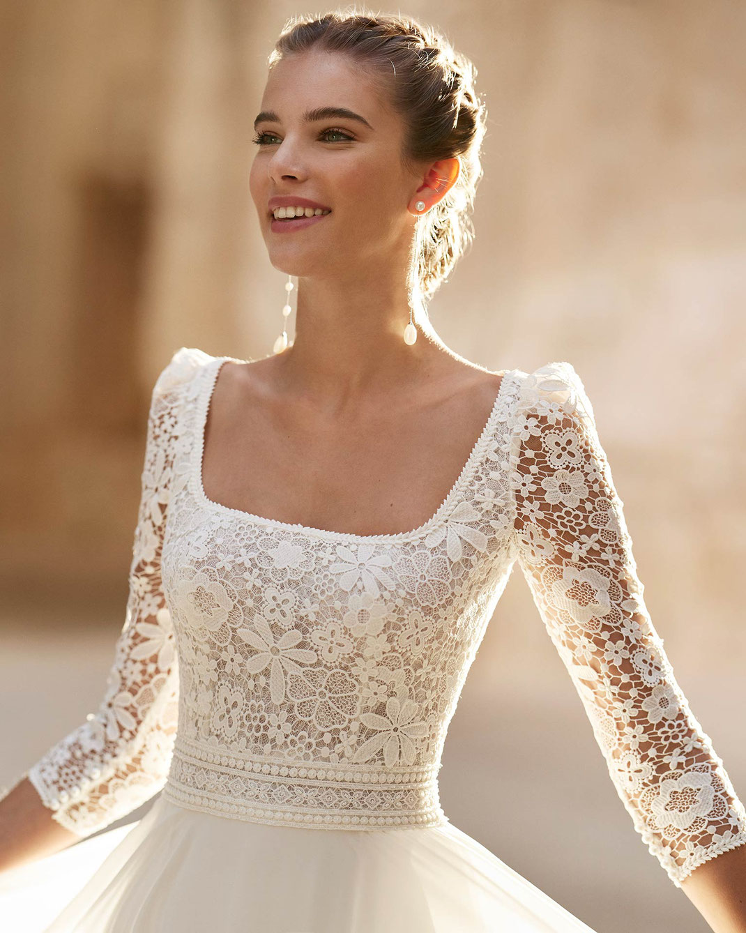 Lachende Junge Frau trägt das Brautkleid Hanny aus der Alma Novia Kollektion 2025