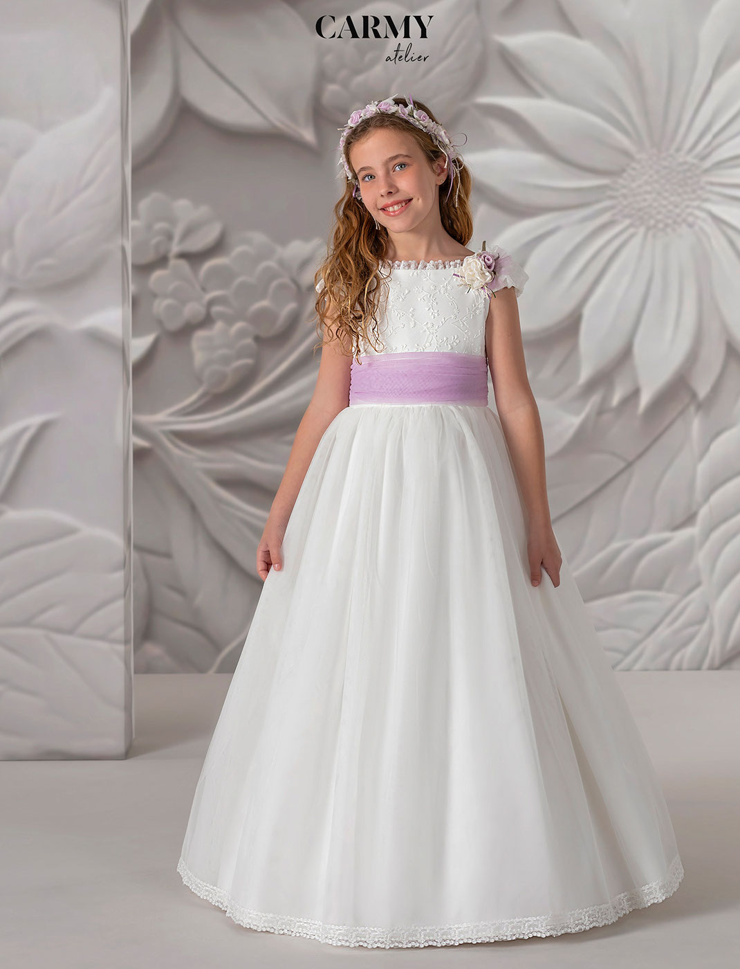 Mädchen trägt ein weisses Carmy Kommunionkleid Kollektion