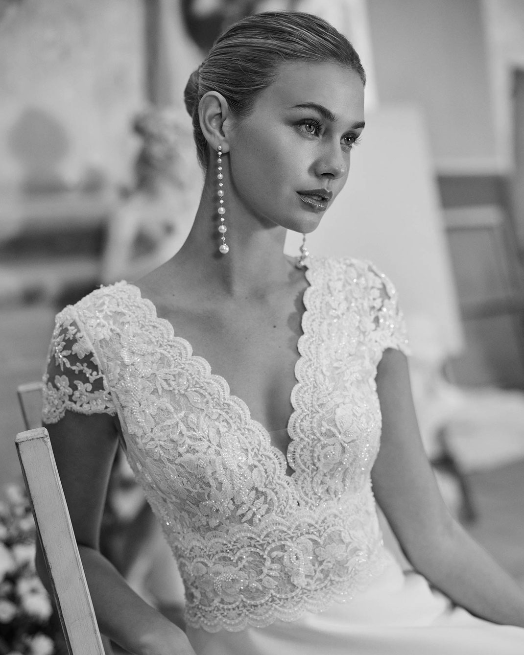 Junge Frau mit schönen langen Ohrringen von Rosa Clara trägt das Brautkleid Malou aus der Aire Barcelona Kollektion 2026