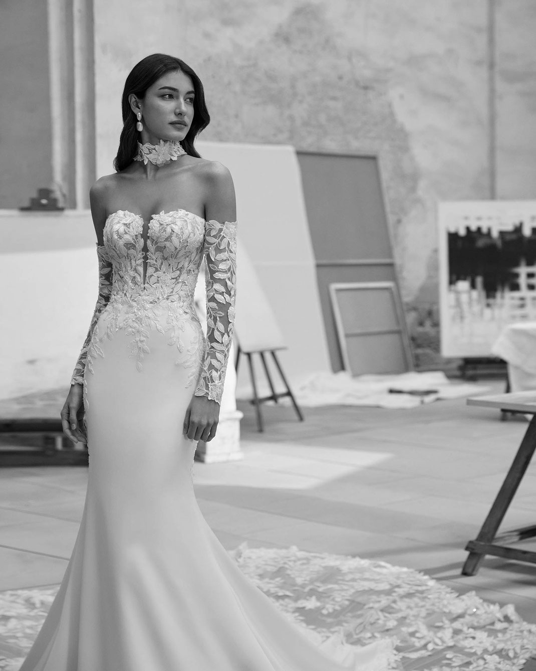 Junge elegante Frau in einem Künstleratelier trägt das Brautkleid Mariela aus der Aire Barcelona Kollektion 2026