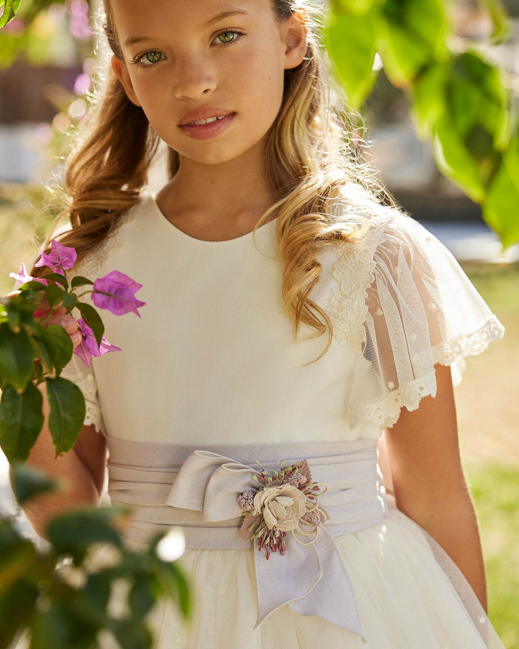 Mädchen trägt das Rosa Clará First Kommunionskleid mit Schleife