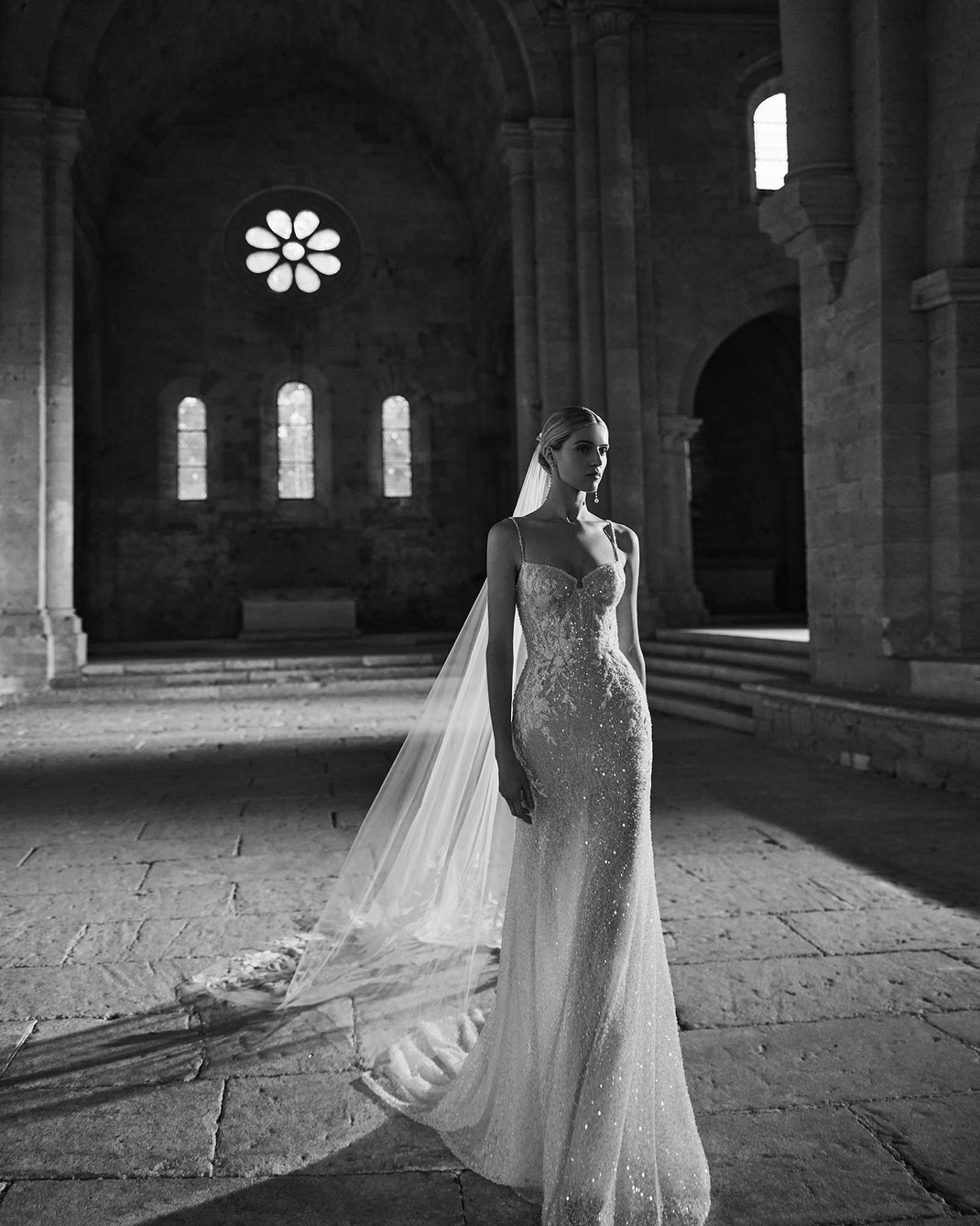 Junge Frau in einem monumentalen Saal trägt das Brautkleid Loren aus der Rosa Clará SoftKollektion 2026