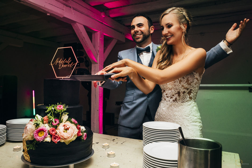 Glückliches Brautpaar beim Torte anschneiden