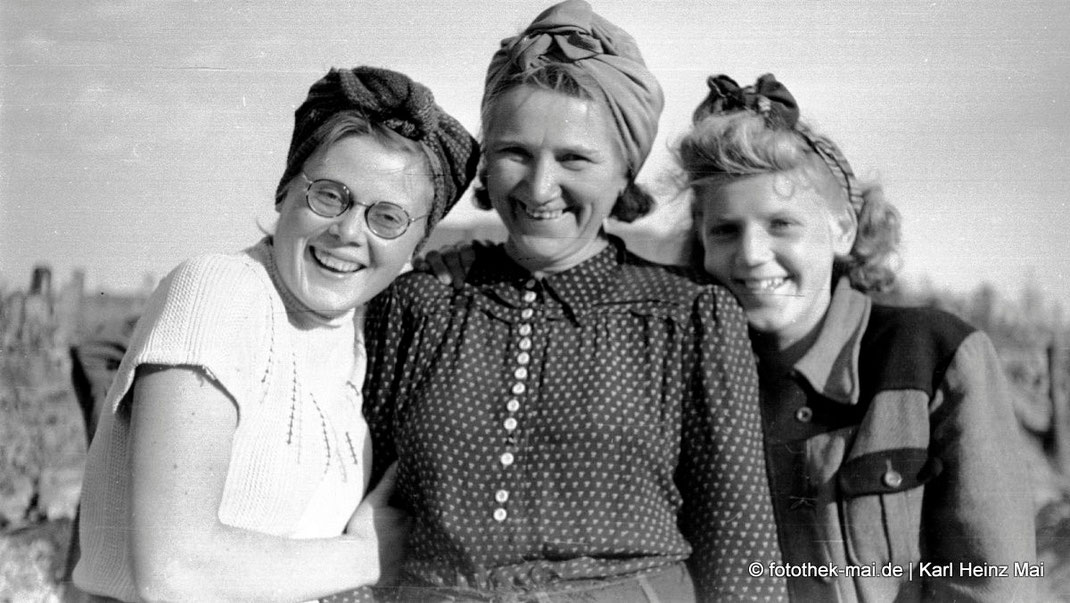 drei jubge Frauen beim Enttrümmern und Ziegelsteine bergen