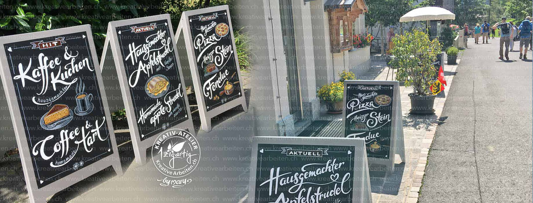 Bild zeigt 3 grosse Stelltafeln mit handgefertigten Bemalungen mit Handletterings und Zeichungen von Torte, Kaffee, Apfelstrudel, Pizza, Fondue...