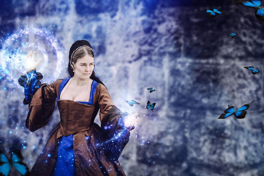 Tudor Zauberin auf Burg Hellenstein, Heidenheim. Magisches Fantasy Fotografie Shooting aus Ravensburg. Fantasievolle Bearbeitung und Retusche mit Zaubern und Schmetterlingen