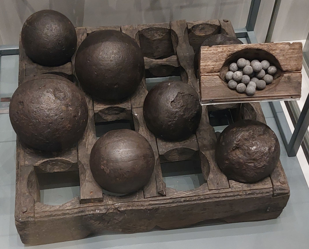 Holzuntergestelle (shot racks) für Kanonenkugelpyramiden - hier mit unterschiedlichen Kalibern. Rechts oben sind Musketenkugeln für Vorderladergewehre der Soldaten (militärische Schiffsbesatzung).
