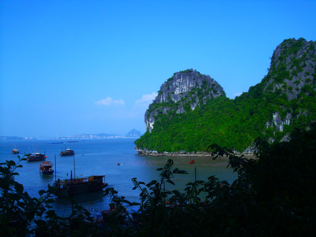 Mystischer Nebel über den Karstfelsen der Halong Bucht am frühen Morgen. Bildunterschrift: Die Lichtverhältnisse und der oft neblige Morgen verleihen der Bucht eine magische, fast unwirkliche Stimmung.
