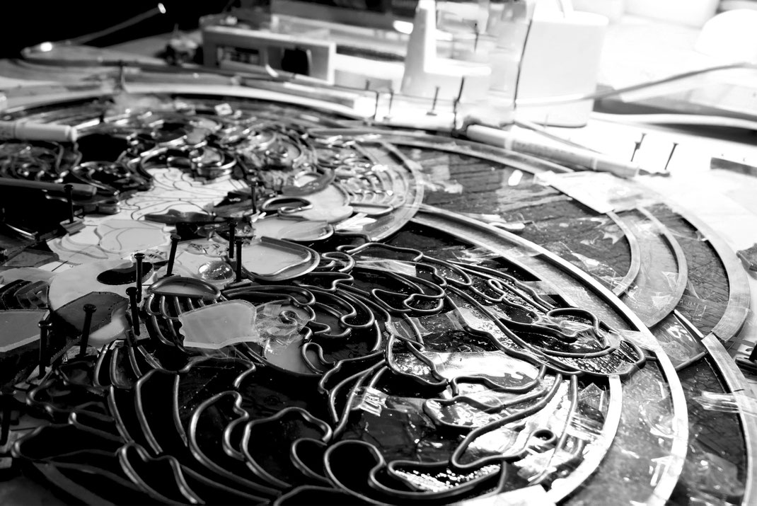 alt="ステンドグラス制作工程の写真。プロ作家が手がける効率的な直線的デザインと、工芸士が繊細に仕上げるアンティークガラス作品との違いを象徴する制作現場｜工房ルヴェール"