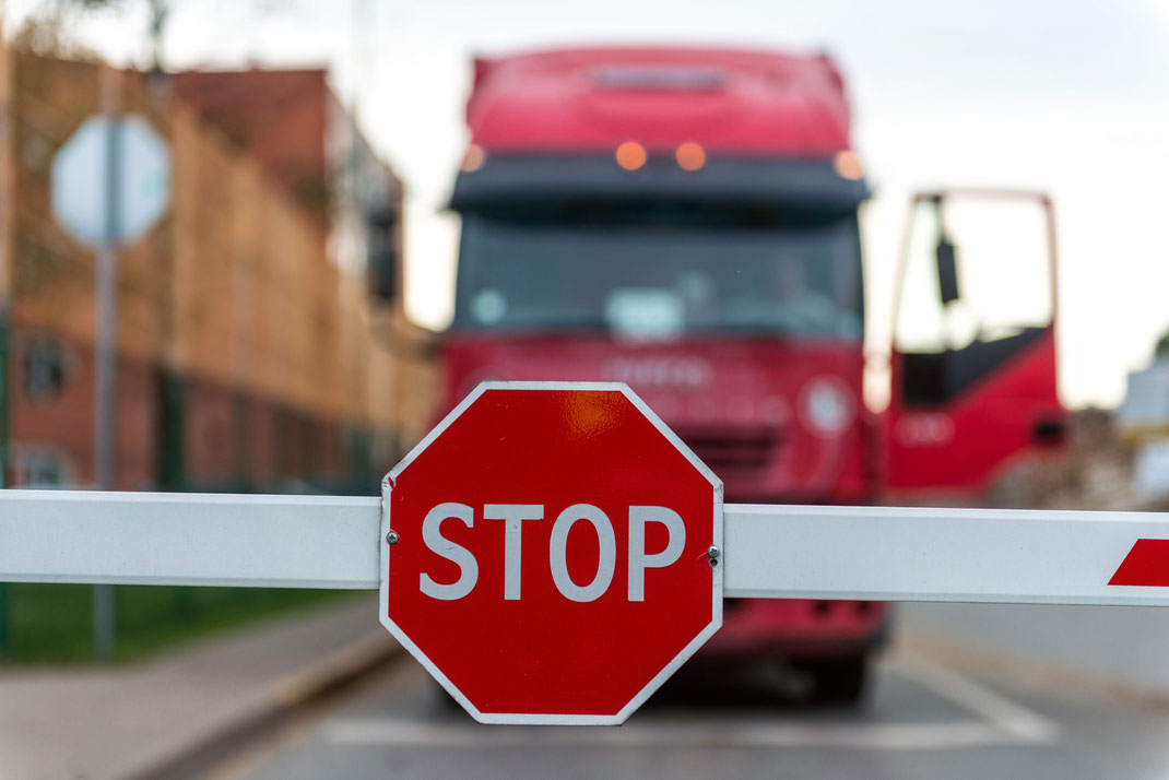 Rotes Stoppschild vor LKW an geschlossener Schranke – Verkehrssicherheit, Kontrolle und Logistik im Straßenverkehr