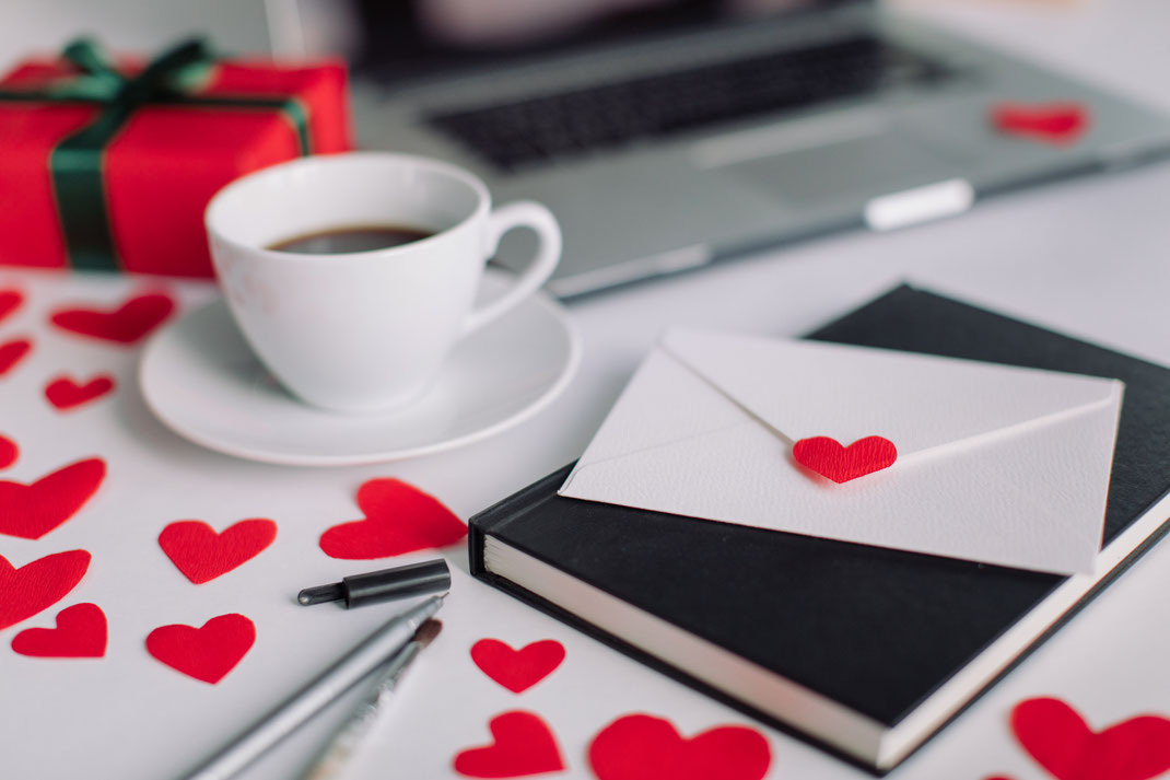 Romantisches Arrangement mit Kaffeetasse, Briefumschlag mit Herz, Notizbuch und Geschenk – Valentinstag, Liebe und persönliche Botschaft
