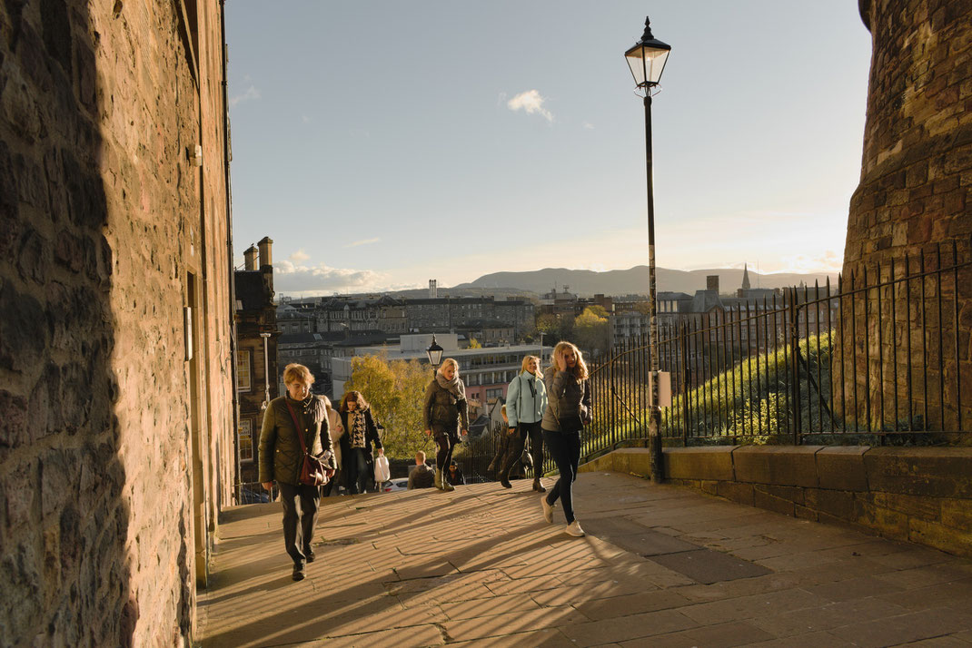 people walking up steps in sunshine