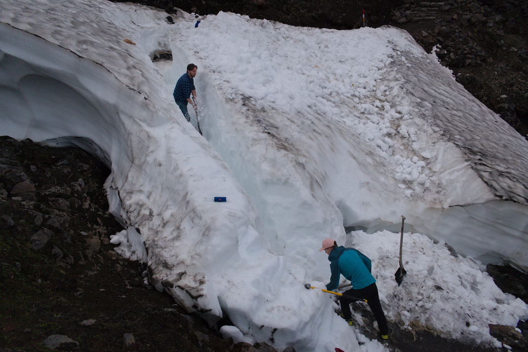 Landmannalaugar snow. Two young men digging snow. 