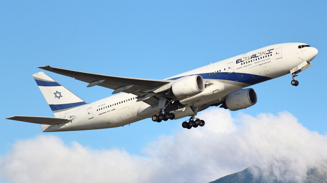 plane flying in a blue, cloudy sky