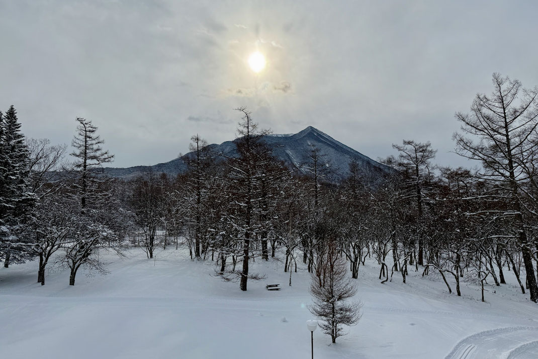 朝日の中に浮かぶ雪の男体山。奥日光の冬の夜明けの風景。