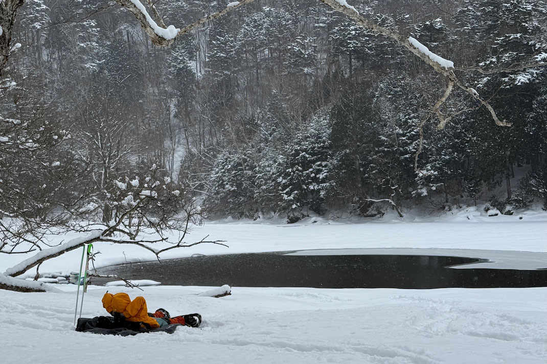 雪に覆われた奥日光の湖畔に寝転んで、静かに目の前の景色を眺める、よる森の参加者。