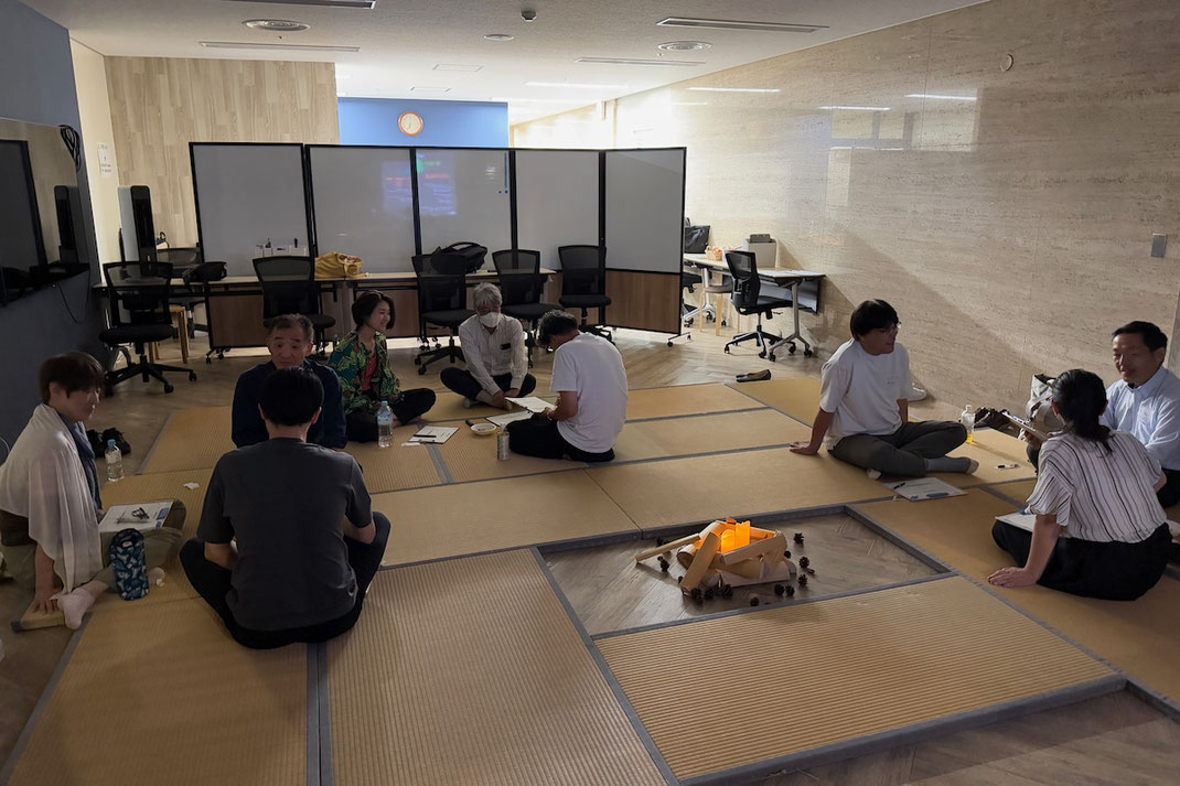 会議室に敷かれた畳の上で、内省を深める参加者の対話の様子