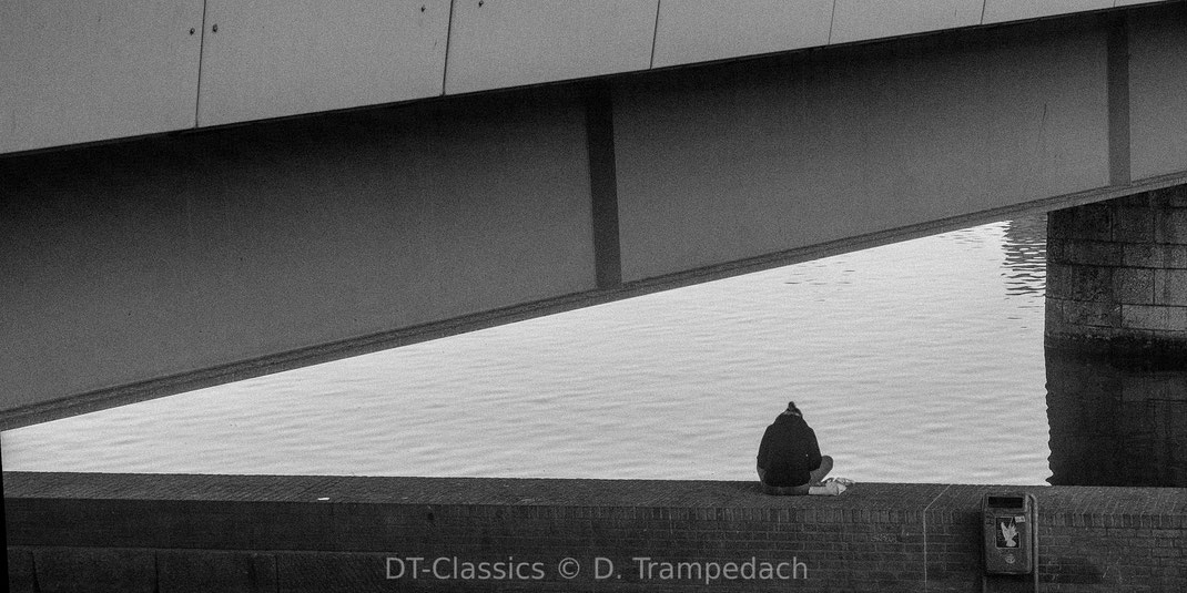 Street Photography, Brücke, eine Person alleine sitzend.