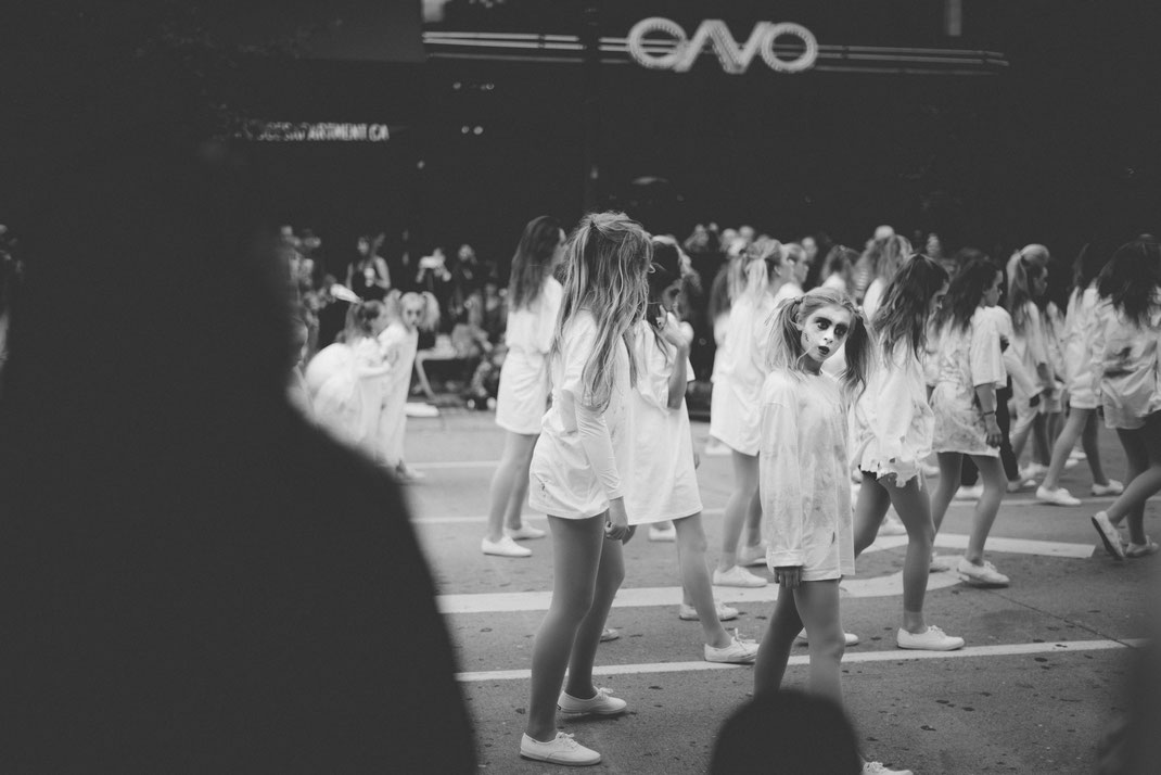 creepy looking girl dancing at a Halloween parade