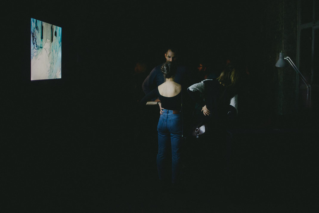 a white girl in a back-free dress talking to others on the exhibition