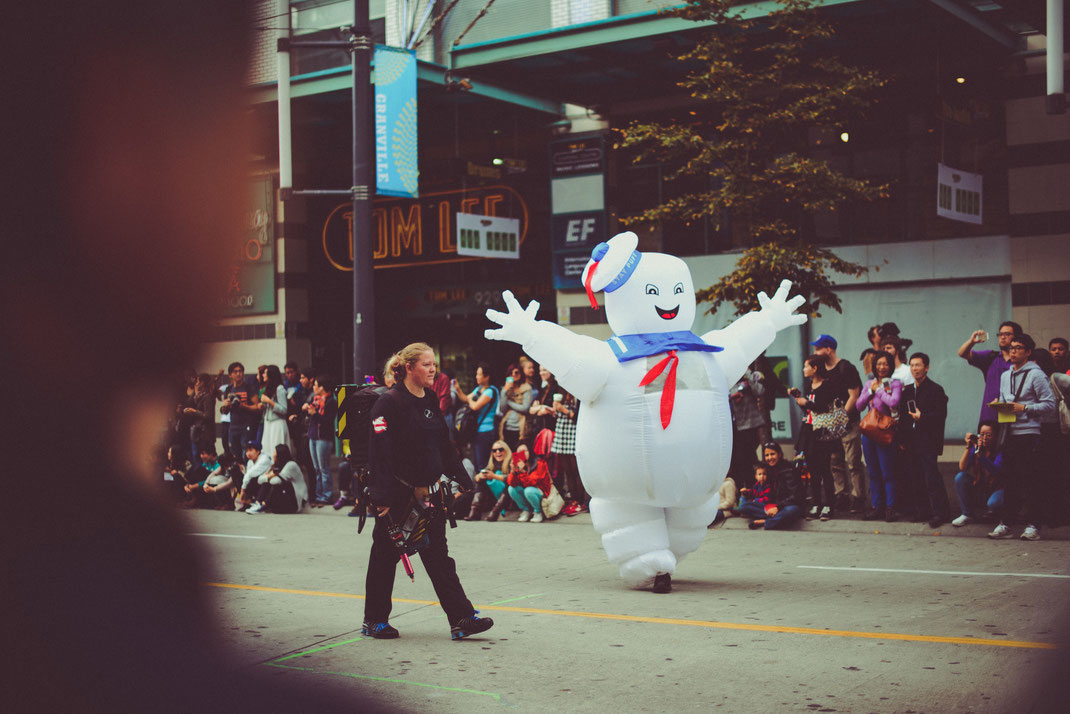 Marshmallow man and a member of the Ghostbusters walking on the Halloween parade