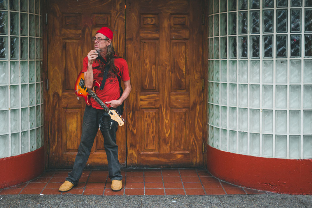 a street musician with a guitar standing in an entrance
