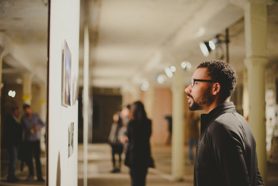 A black man looking at pictures at the exhibition