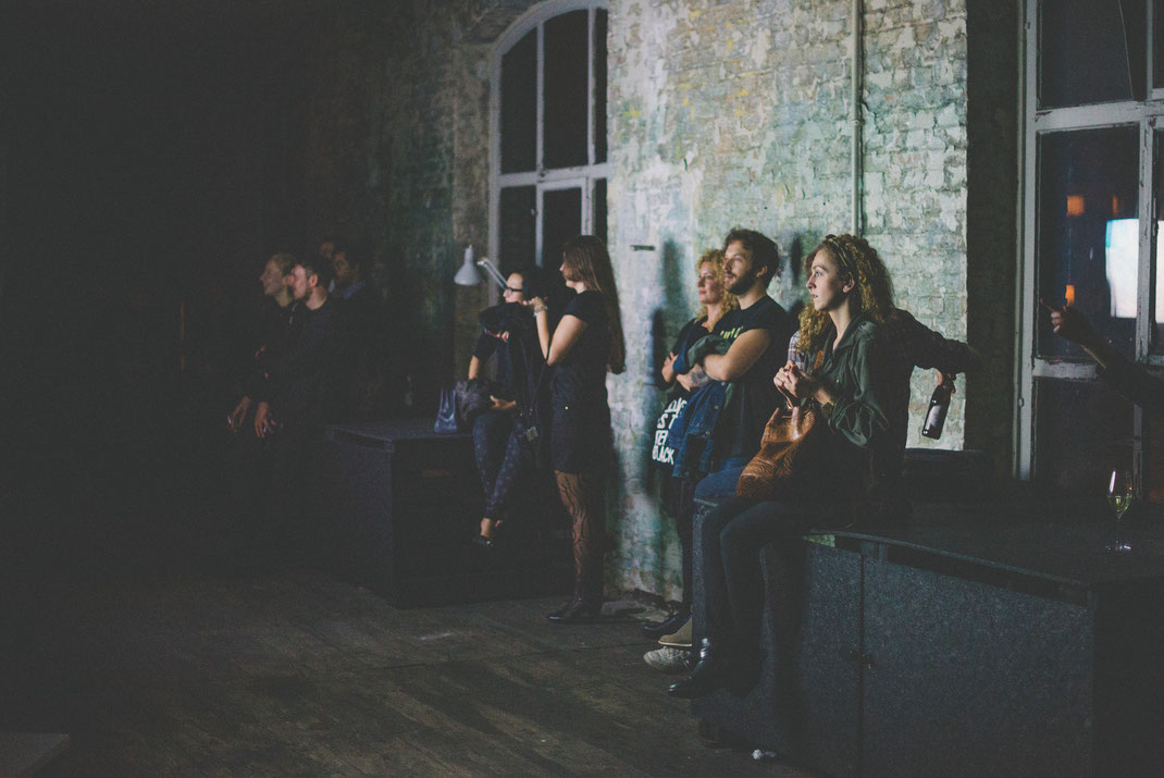 visitor watching the contributions to the awards. the room is just illuminated by the lights of the monitors