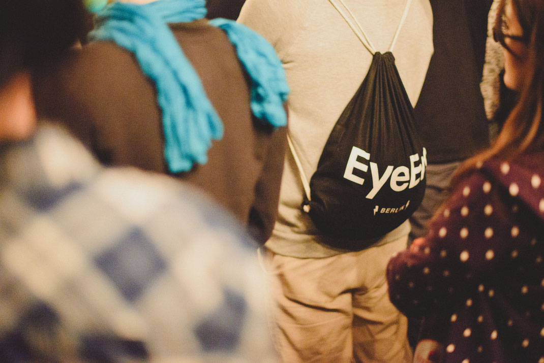 a man standing in the crowd with an eyeem bag