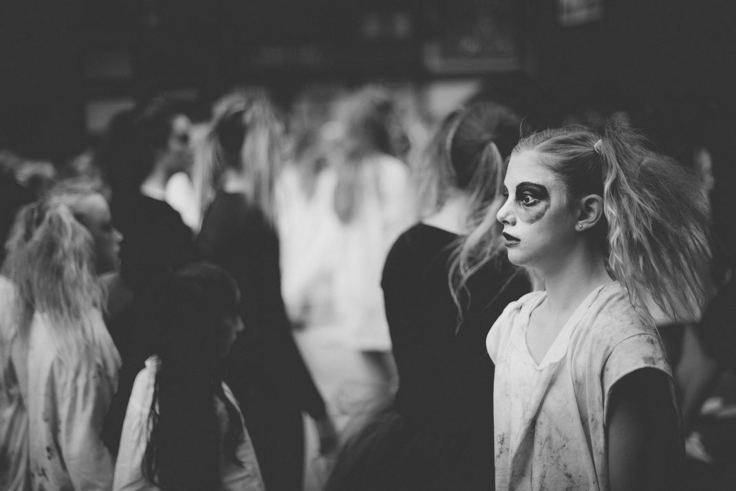 a creepy blonde girl walking at a Halloween parade